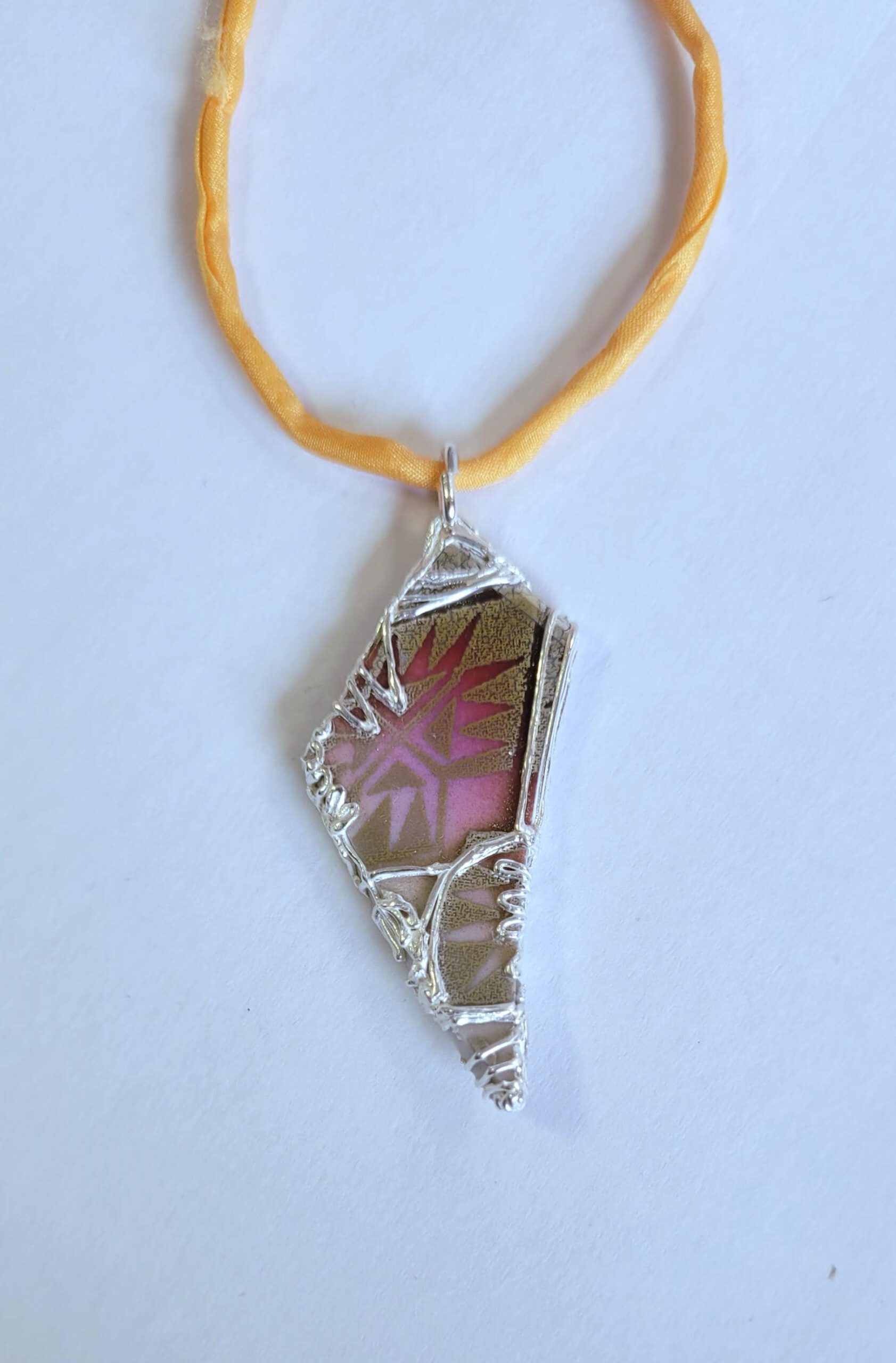 spitze Porzellanscherbe in Silber gefasst