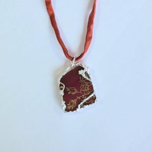 dunkelrote Porzellanscherbe in Silber gefasst